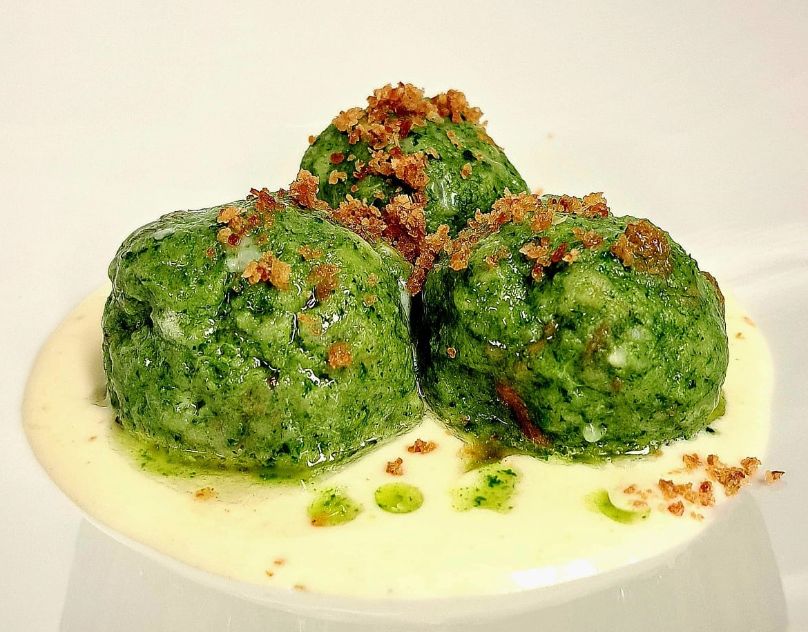 Canederli al tarassaco su fonduta di Casolet con polvere di speck