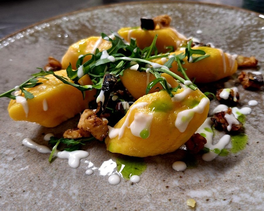 Gnocconi di zucca con fonduta di taleggio e melanzane viola, rucola croccante